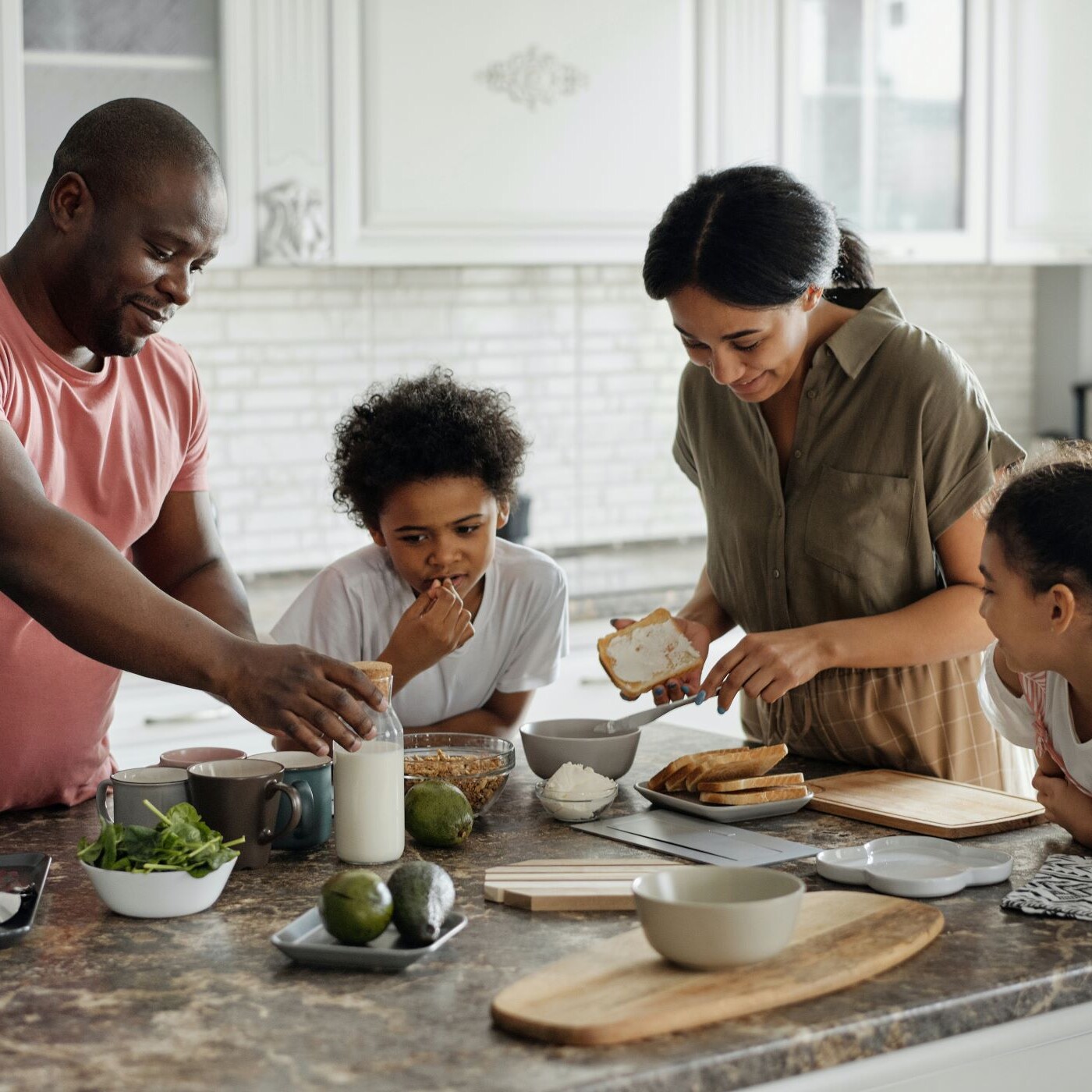 Family uses household goods products to cook a meal together in the kitchen.