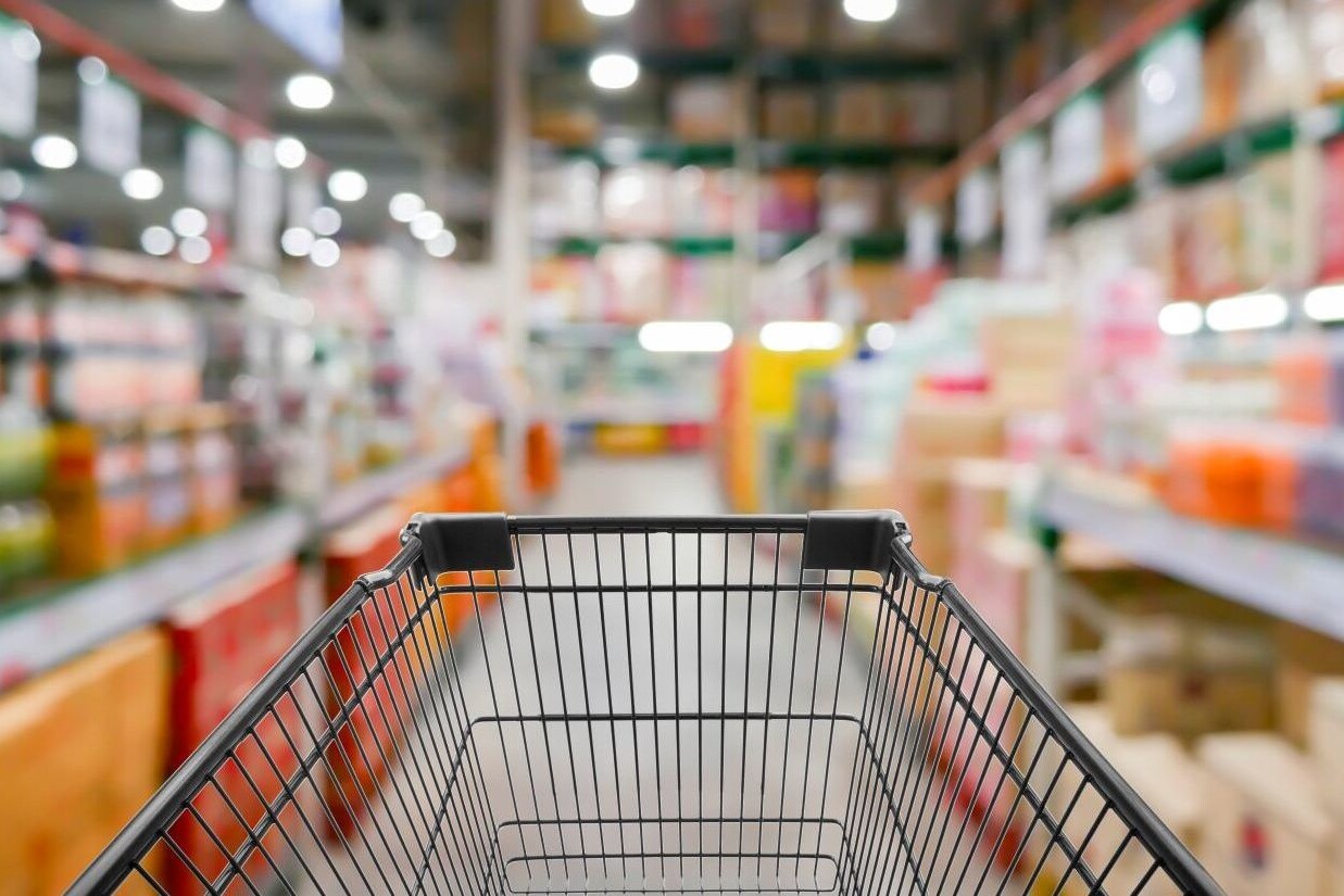 In focus shopping cart with out of focus grocery aisles in the background.