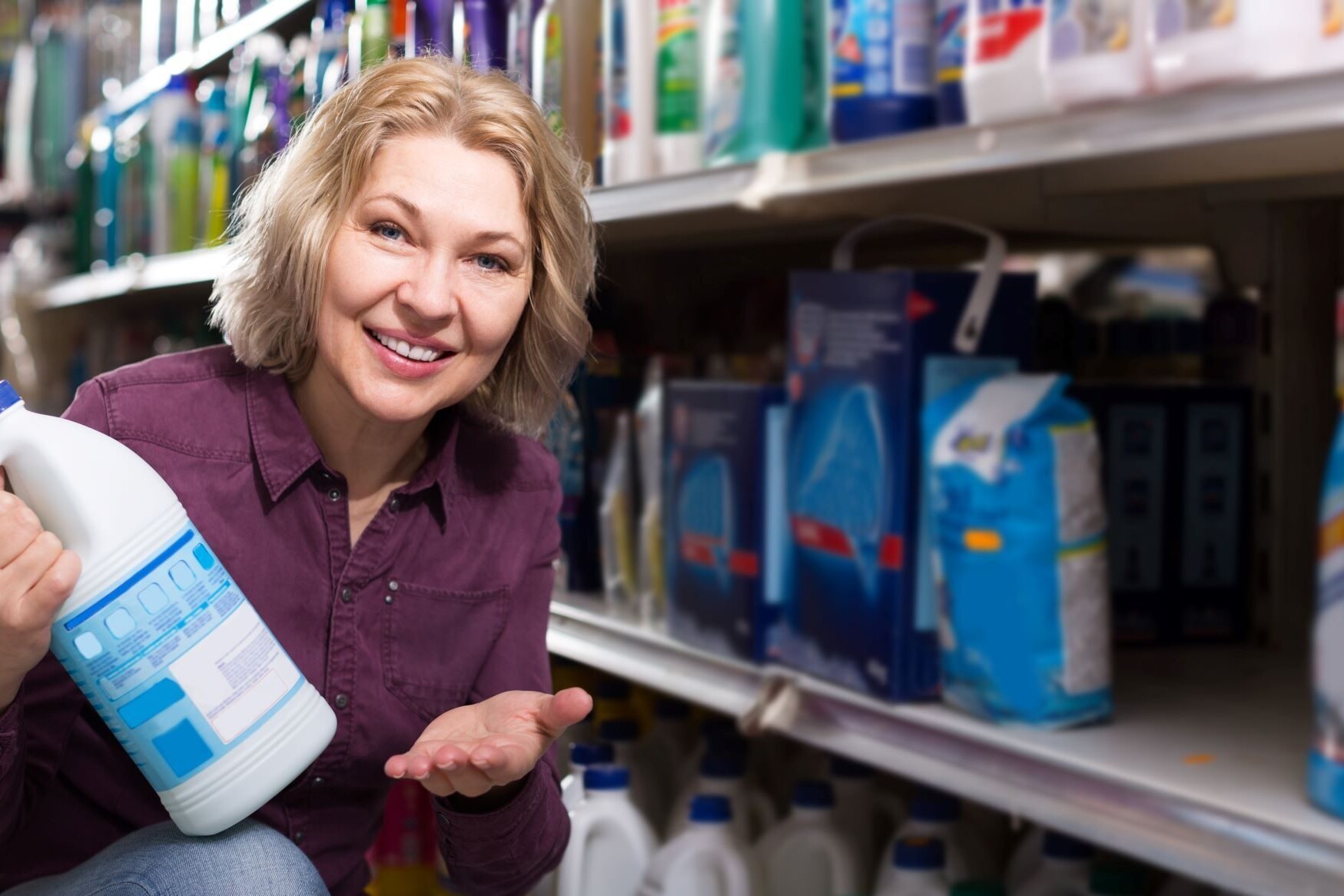 Woman consumer shops for laundry detergent in the supermarket.