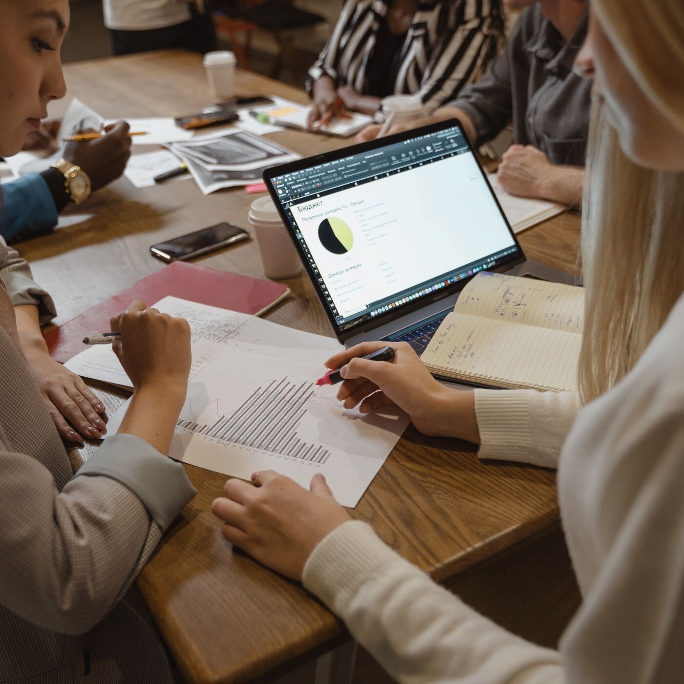 A businesswoman and her boss review charts at a conference table