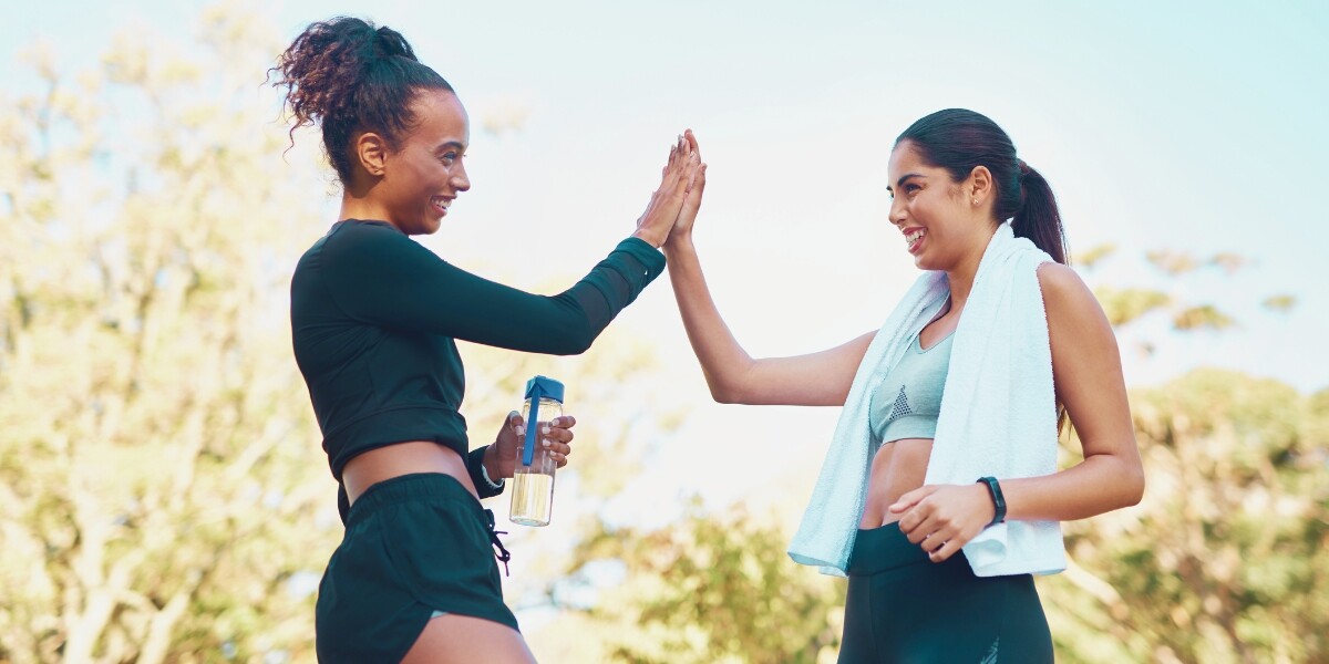 Two women high fiving after exercising