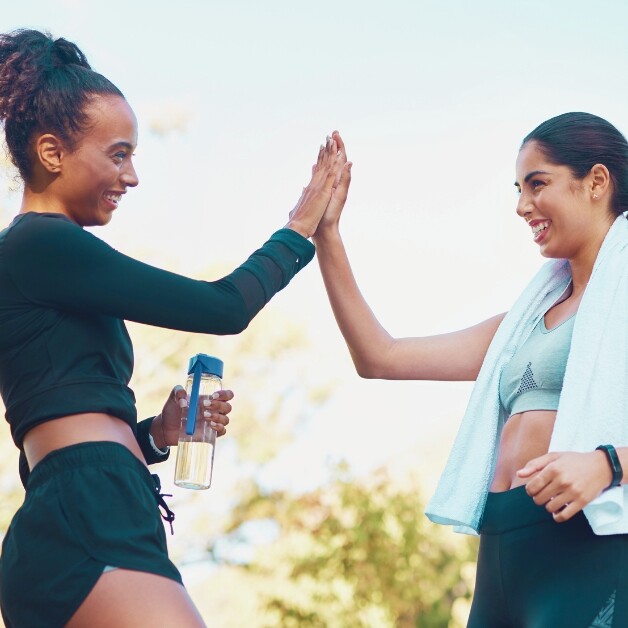 Two women high fiving after exercising