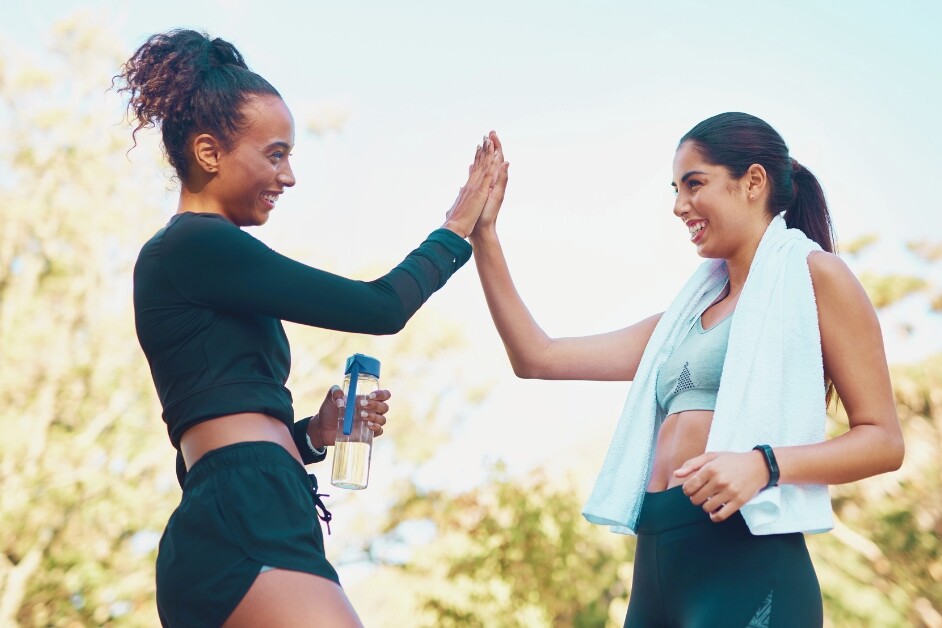 Two women high fiving after exercising